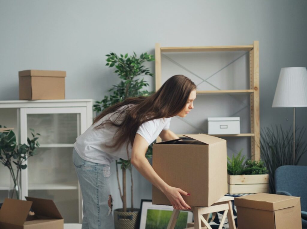 Woman moving boxes around the house